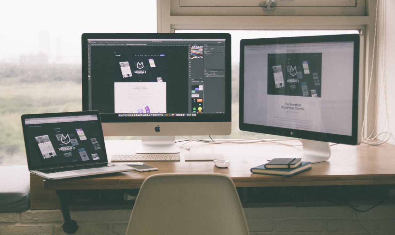 journey Stylish and efficient workspace with multiple monitors, laptop, and smartphone, showcasing a web design project.