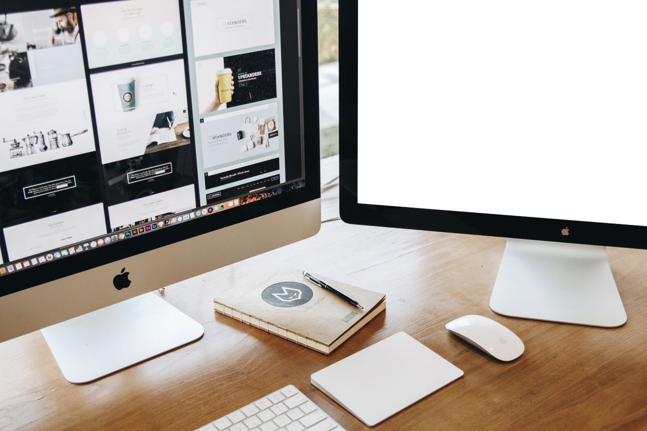 why-choose-us High-angle view of a stylish work desk featuring dual monitors, keyboard, mouse, and modern accessories.